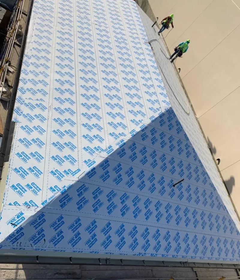 Professional roofers installing underlayment on a metal roof in Gantt